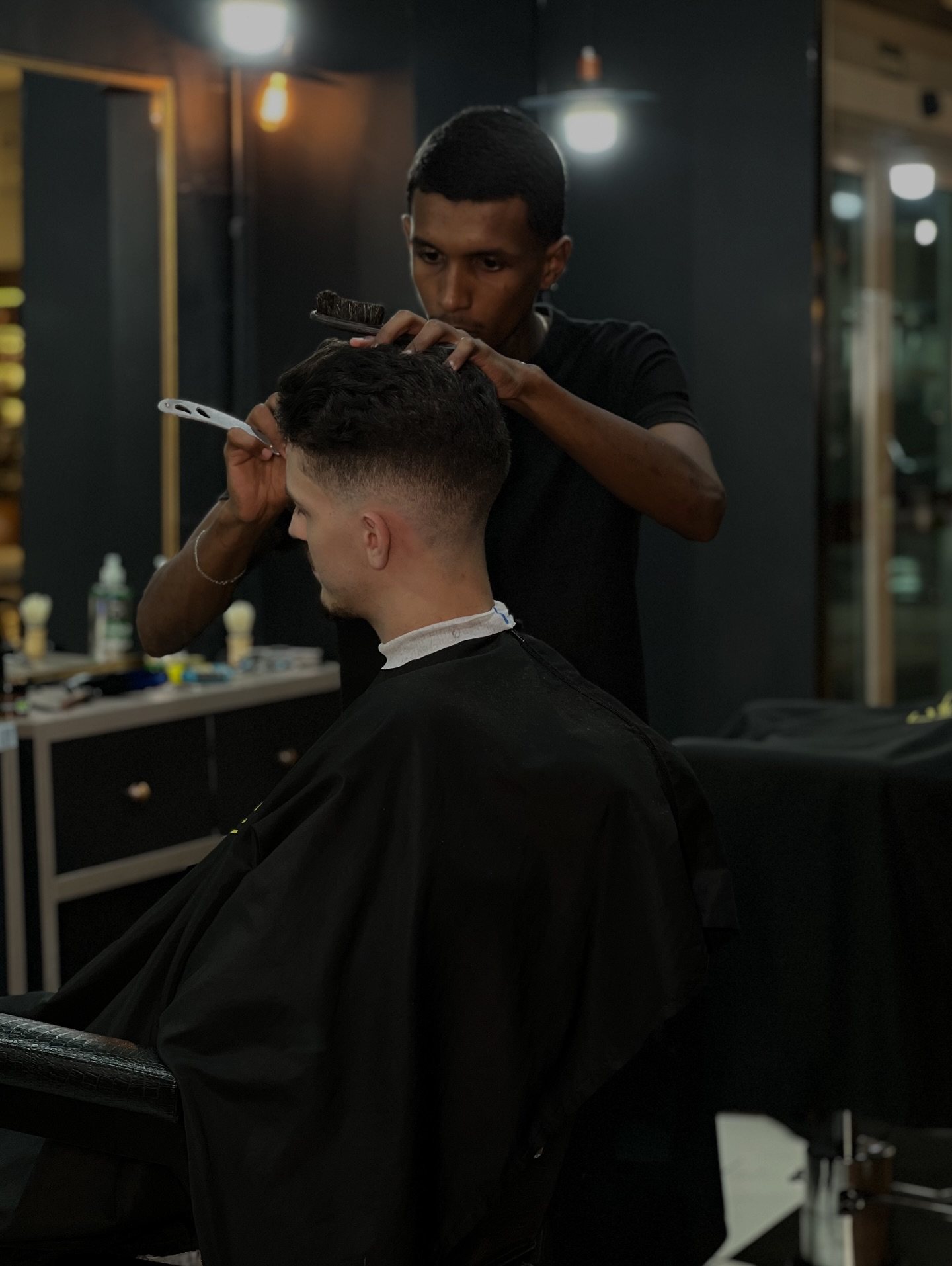 Interior da Vegas Barbearia com cadeiras e iluminação quente